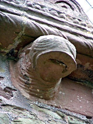 Monster head with concertina like striations and large rubbery mouth and tongue. Kilpeck Herefordshire.